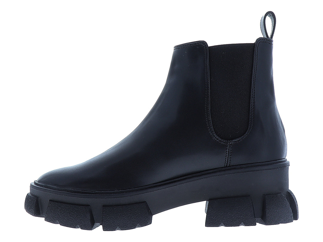 Bota negra de tobillo con suela track gruesa y acabado liso.