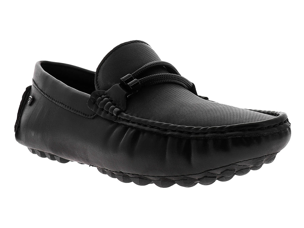 Zapato tipo mocasín color negro con suela texturizada y detalle decorativo en la parte superior.