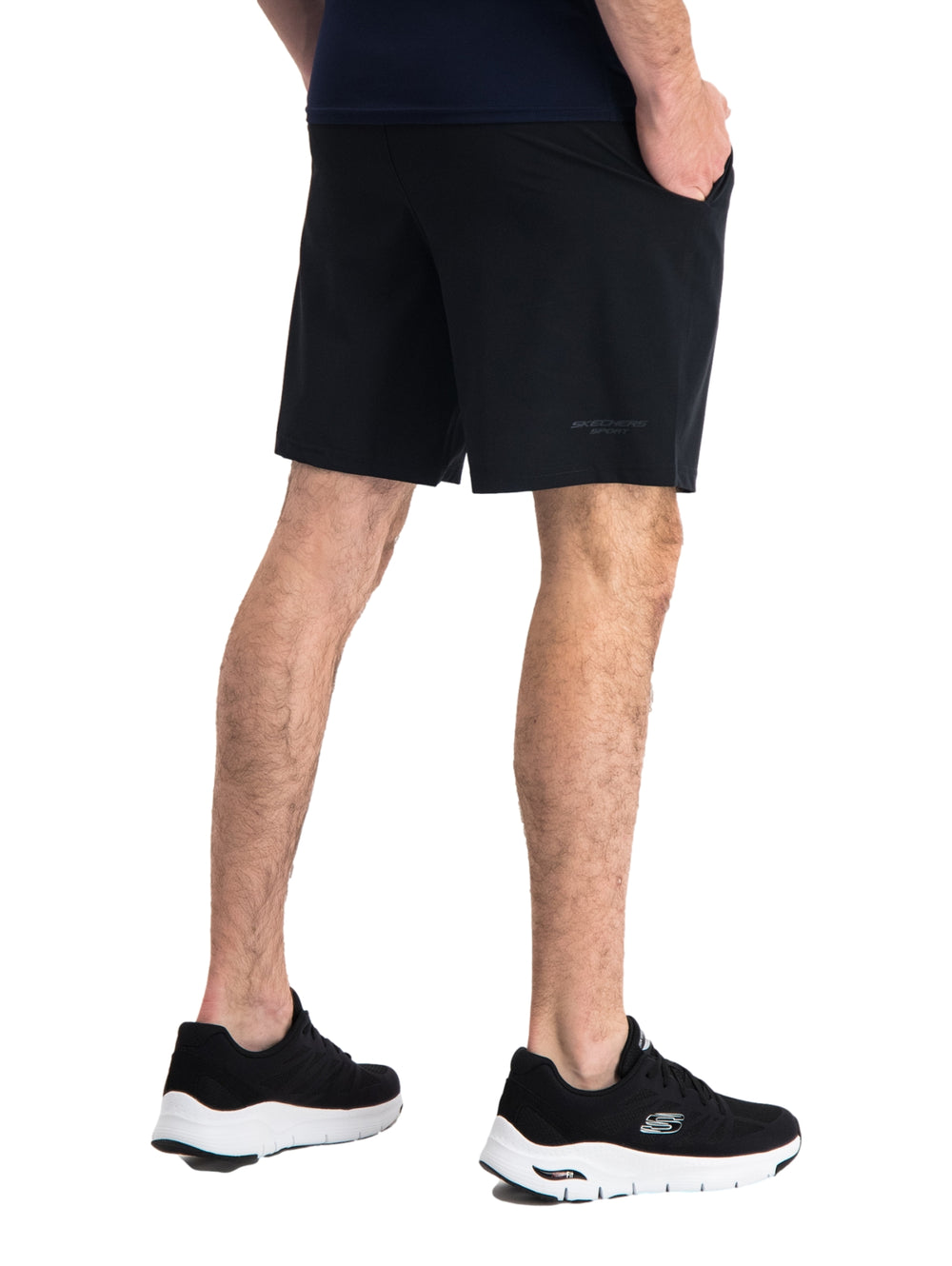 Hombre vistiendo short deportivo color negro de la marca Skechers con calzado deportivo a juego.