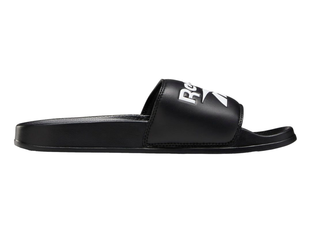 Sandalia deslizable Reebok de color negro con logotipo blanco en la banda superior.