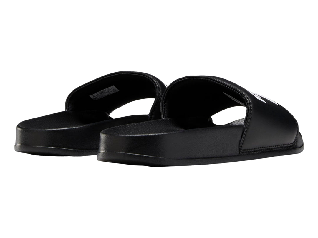 Sandalia deslizable Reebok de color negro con logotipo blanco en la banda superior.