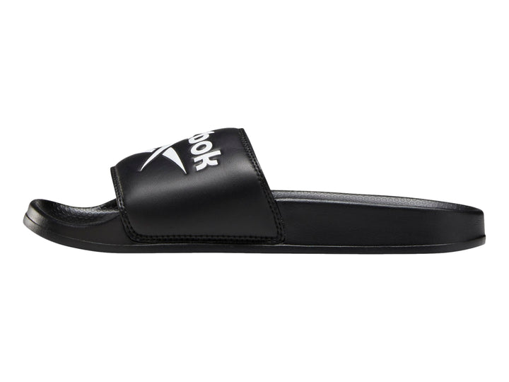 Sandalia deslizable Reebok de color negro con logotipo blanco en la banda superior.