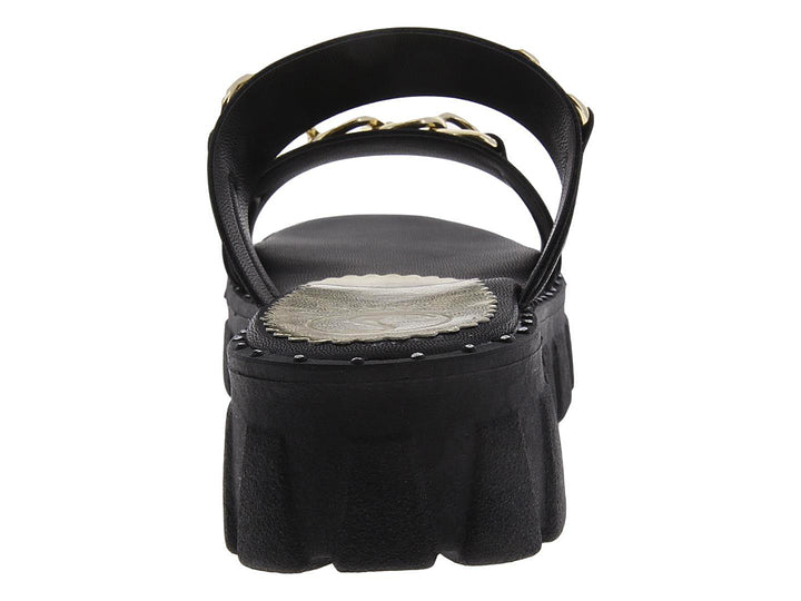 Sandalias negras de plataforma con tiras decoradas con cadenas doradas.