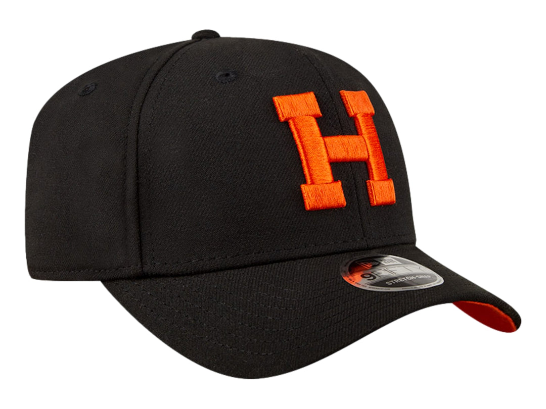 Gorra de béisbol New Era color negro con letra H bordada en naranja y visera inferior naranja.