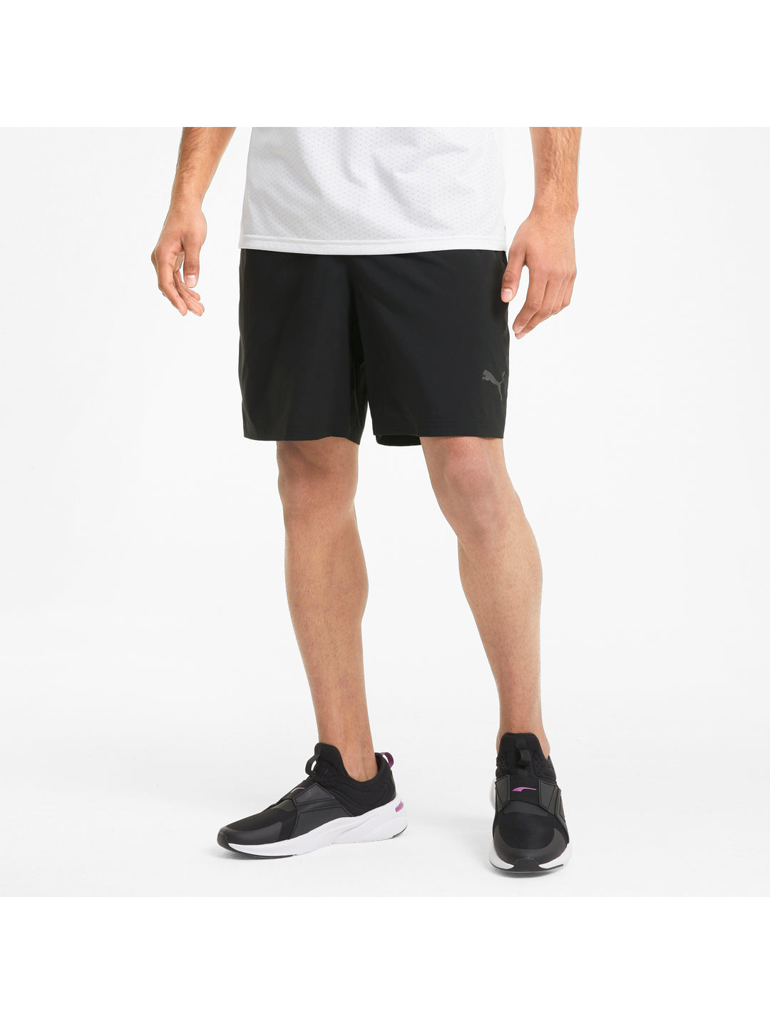 Hombre vistiendo shorts deportivos PUMA de color negro y camiseta blanca.