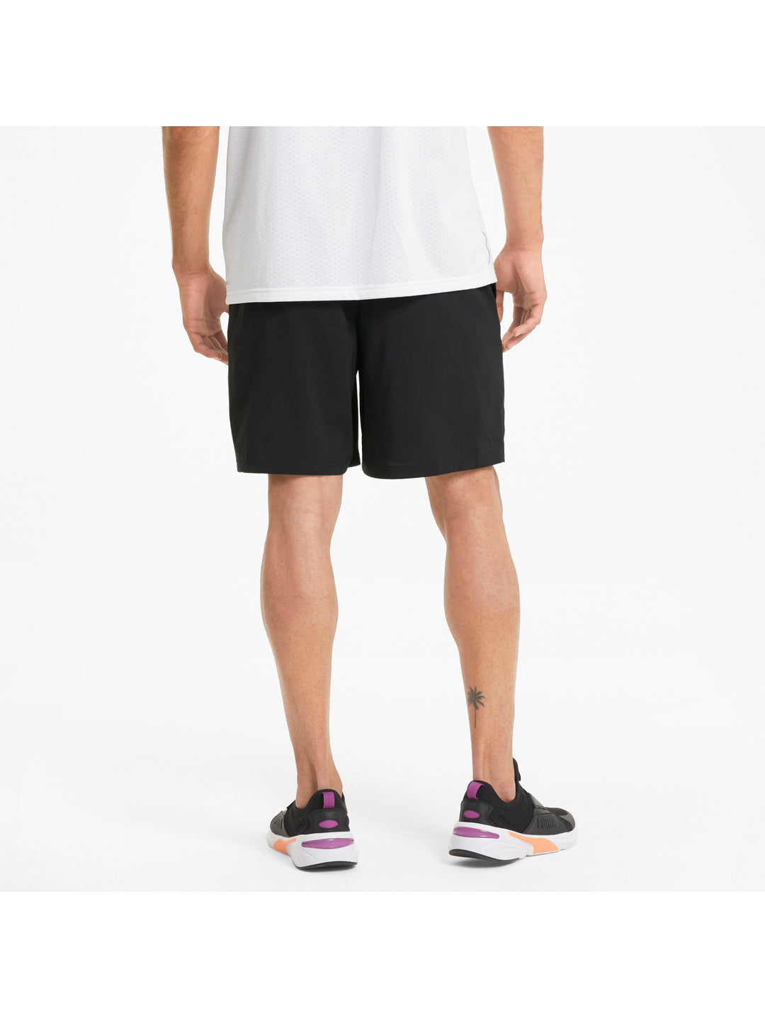 Hombre vistiendo shorts deportivos PUMA de color negro y camiseta blanca.