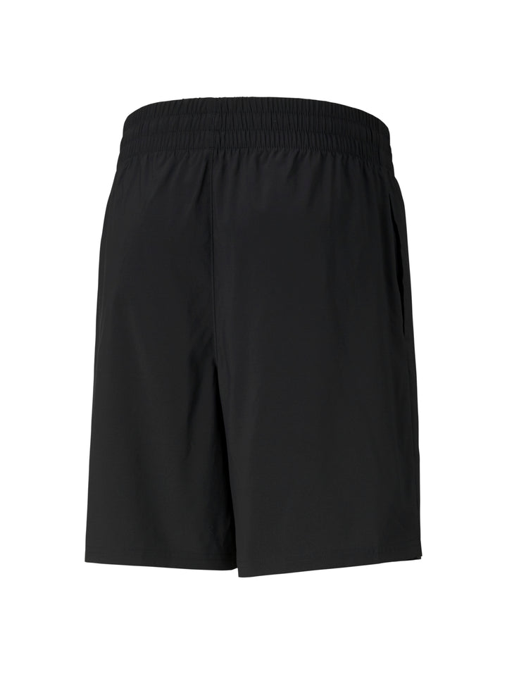 Hombre vistiendo shorts deportivos PUMA de color negro y camiseta blanca.