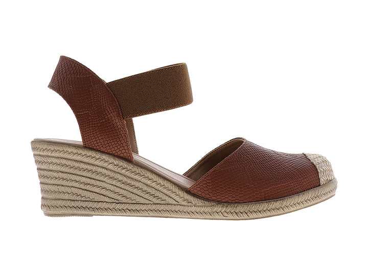 Sandalia de cuña color tan con textura de piel de serpiente y plataforma beige para mujer.