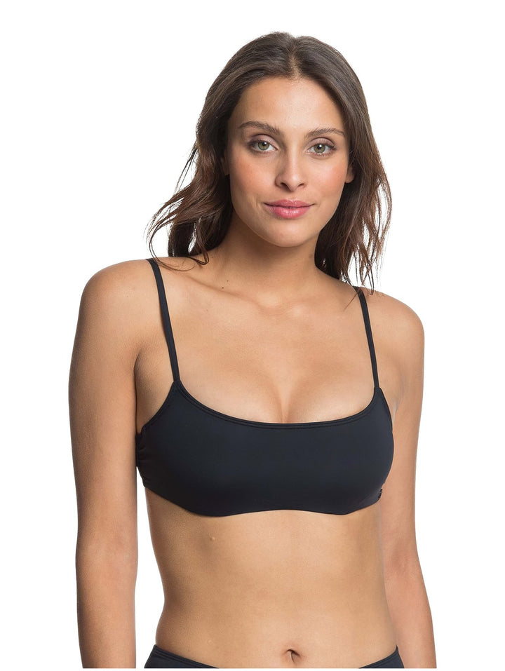 Mujer vistiendo un top deportivo color antracita de la marca Roxy con tirantes delgados.