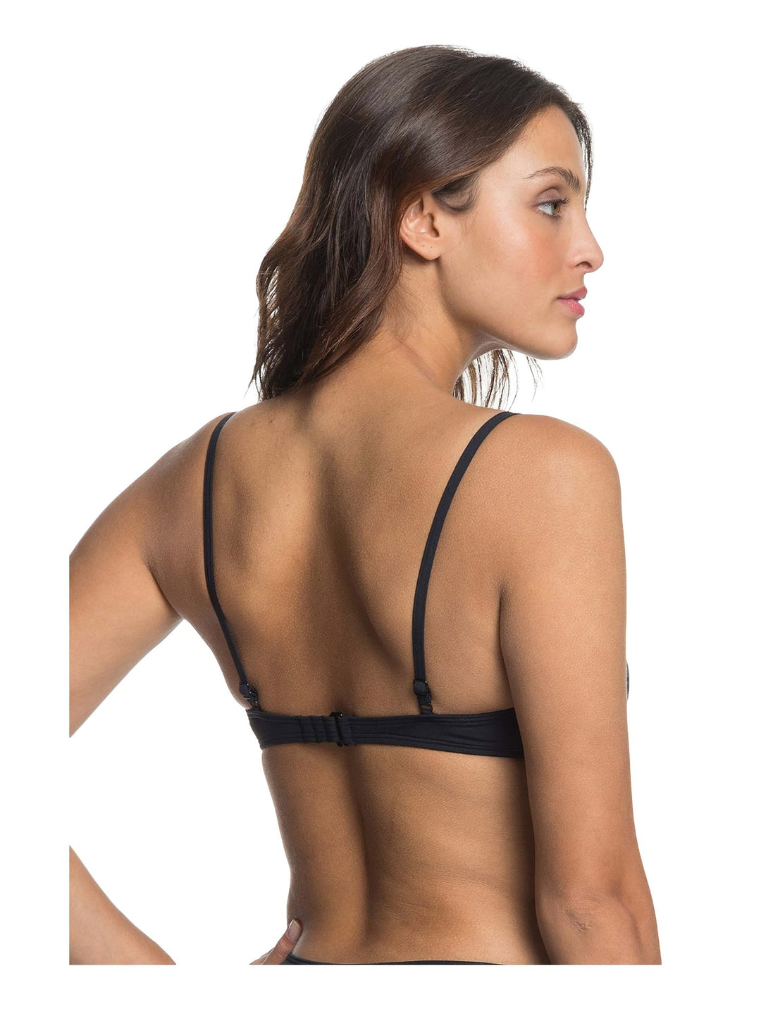 Mujer vistiendo un top deportivo color antracita de la marca Roxy con tirantes delgados.