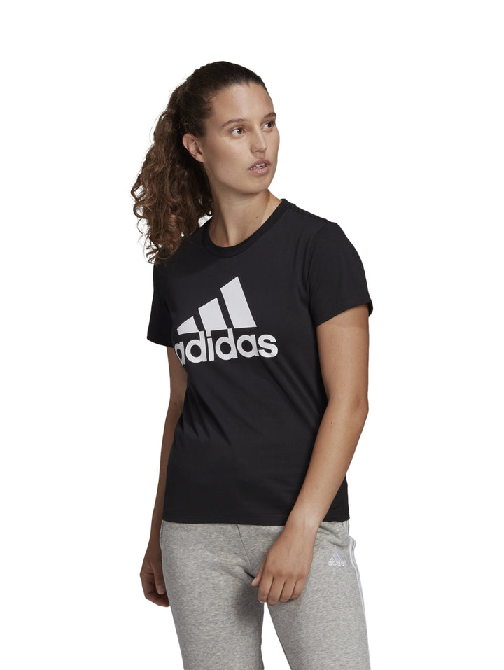 Mujer vistiendo playera negra de manga corta con logo blanco de Adidas.