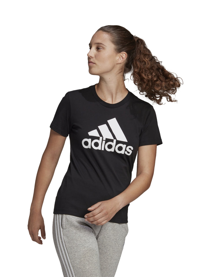 Mujer vistiendo playera negra de manga corta con logo blanco de Adidas.