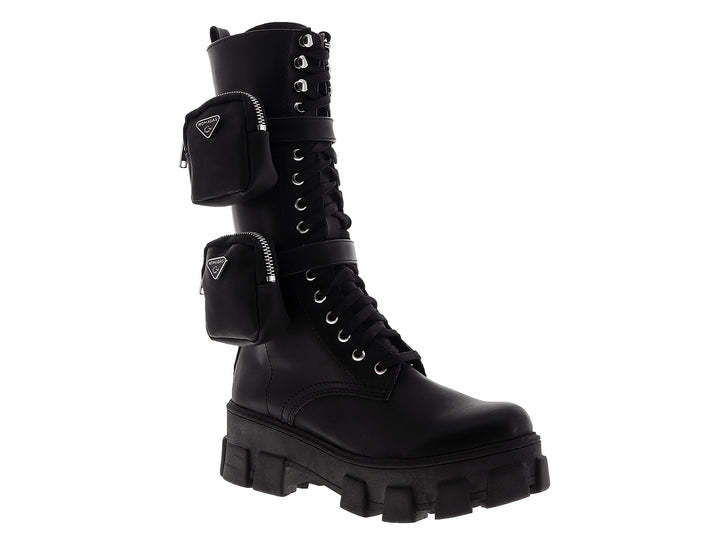 Botas negras de caña alta para mujer con suela de plataforma, agujetas y bolsillos laterales con cierre.