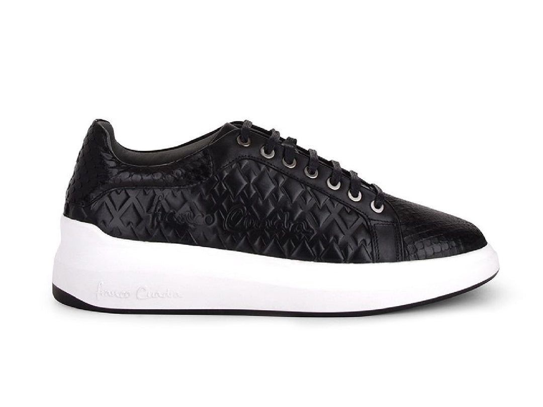 Tenis negros de cuero con textura de pitón y suela blanca ancha para mujer.