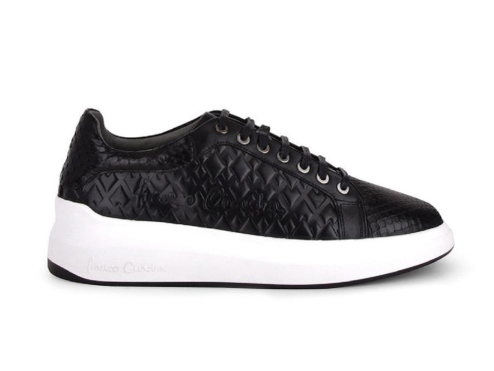 Tenis negros de cuero con textura de pitón y suela blanca ancha para mujer.