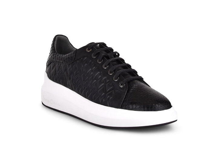 Tenis negros de cuero con textura de pitón y suela blanca ancha para mujer.