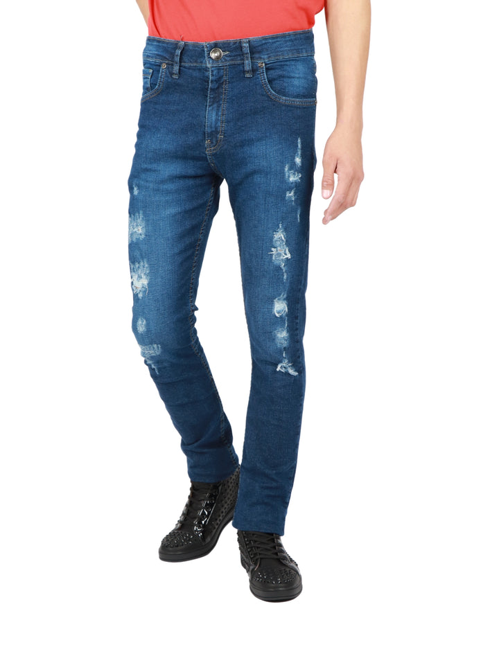 Jeans azules ajustados para hombre con efectos de desgaste y roturas leves.