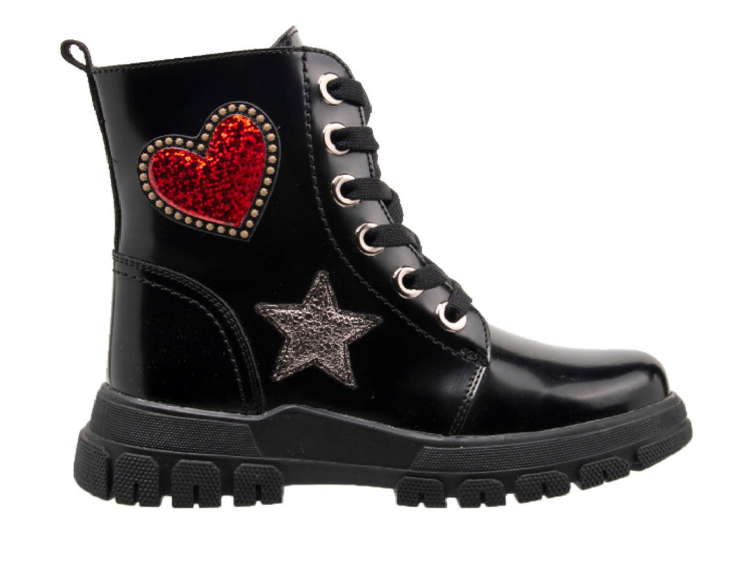 Bota infantil color negro brillante con decoraciones de corazón rojo y estrella plateada.