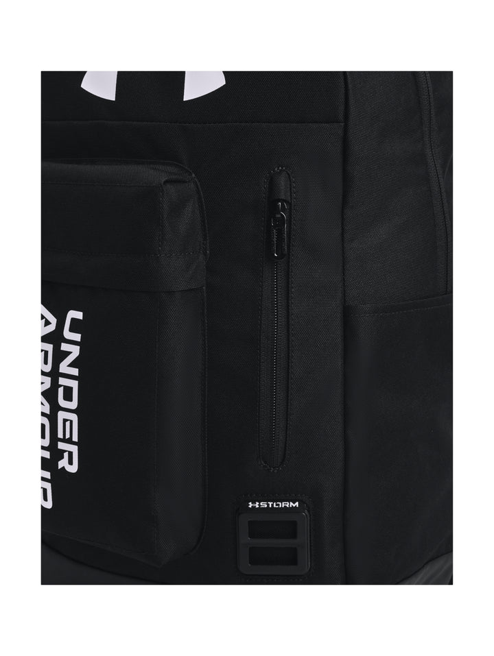 Mochila deportiva Under Armour de color negro con logotipos blancos en el frente.