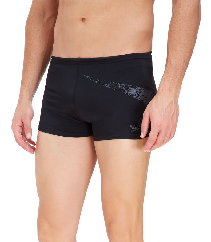 Hombre vistiendo shorts de natación Speedo color negro con detalle gráfico en gris en el lateral.