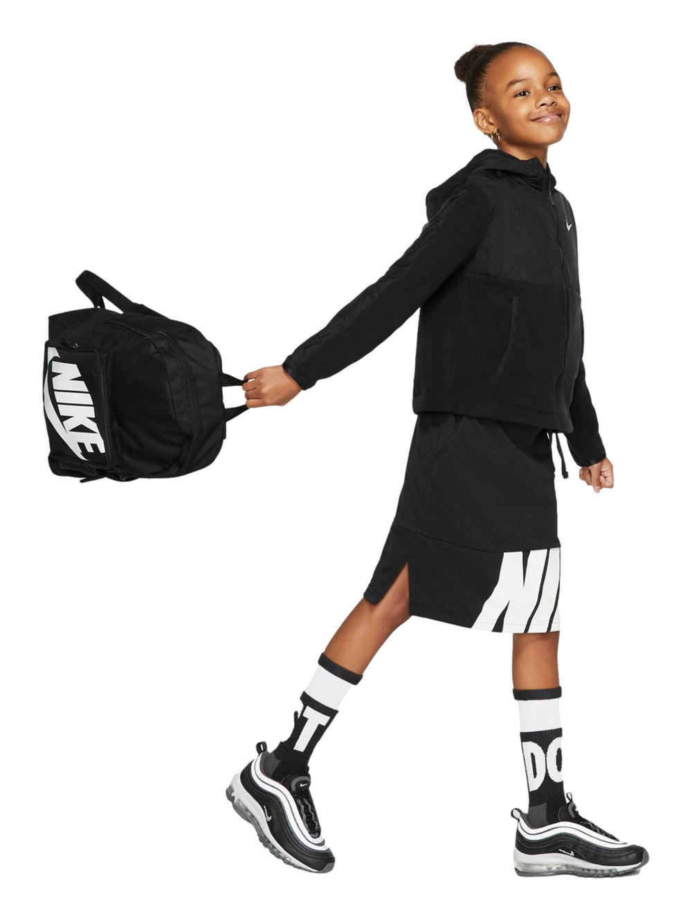 Mochila escolar Nike color negro con logotipo blanco frontal, usada por una niña.