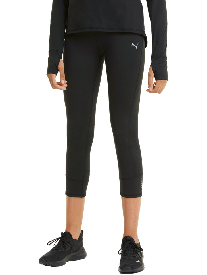Mujer vistiendo mallas deportivas PUMA de color negro, longitud 3/4, ajustadas al cuerpo.