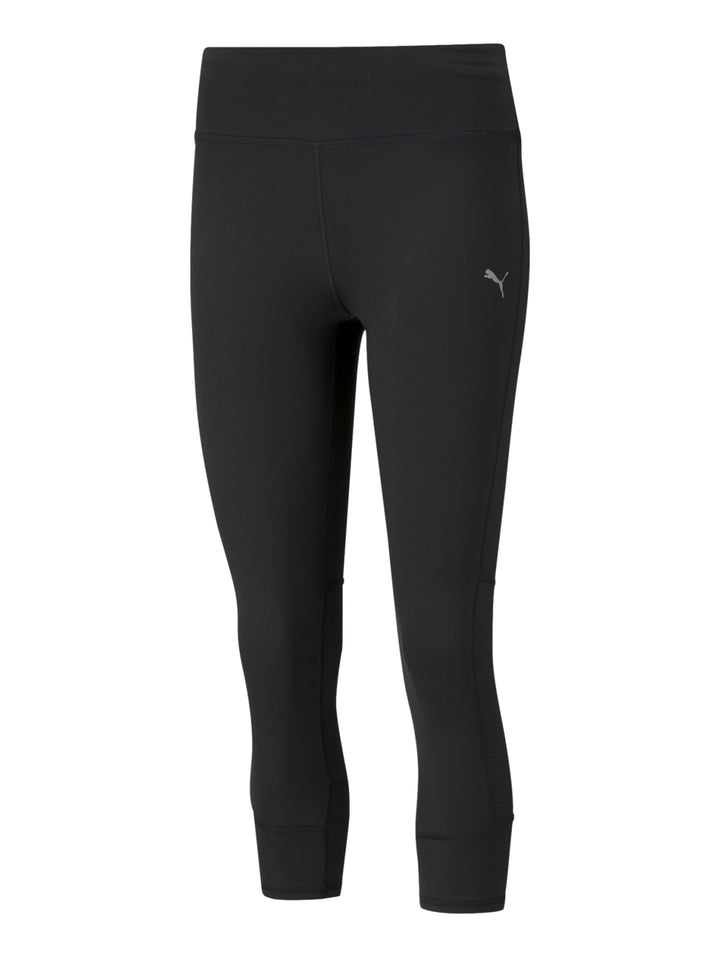 Mujer vistiendo mallas deportivas PUMA de color negro, longitud 3/4, ajustadas al cuerpo.