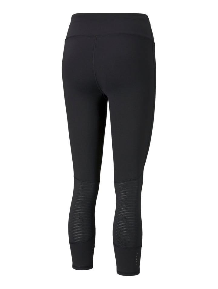 Mujer vistiendo mallas deportivas PUMA de color negro, longitud 3/4, ajustadas al cuerpo.