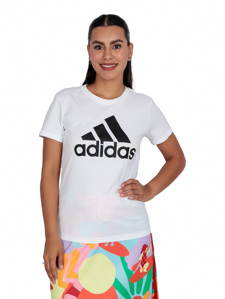 Mujer vistiendo playera blanca de manga corta con logo negro de Adidas en el pecho.