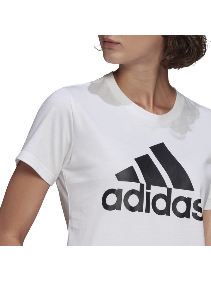 Mujer vistiendo playera blanca de manga corta con logo negro de Adidas en el pecho.