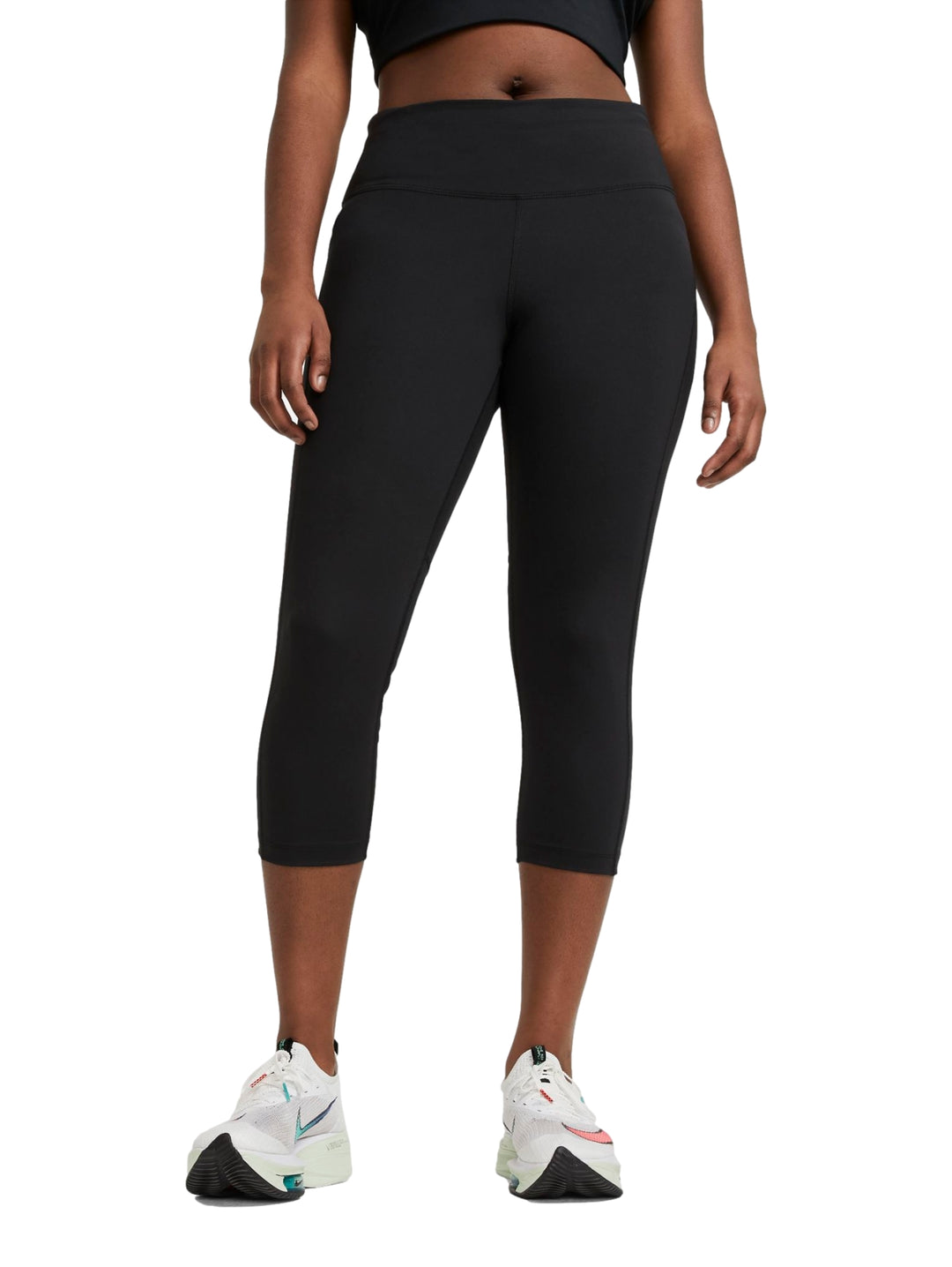 Mujer vistiendo mallas deportivas Nike color negro de corte crop y cintura alta.