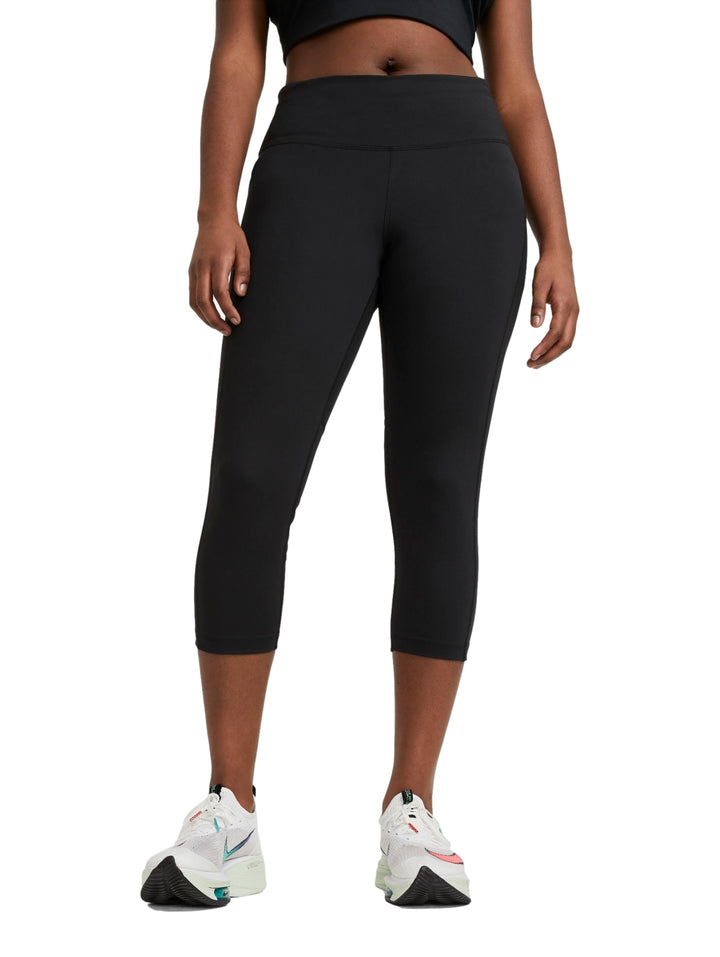 Mujer vistiendo mallas deportivas Nike color negro de corte crop y cintura alta.
