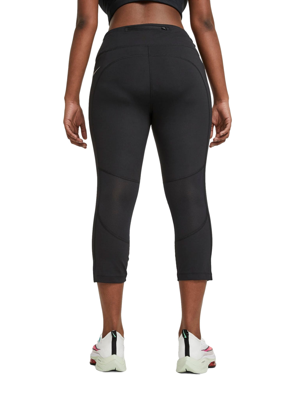 Mujer vistiendo mallas deportivas Nike color negro de corte crop y cintura alta.