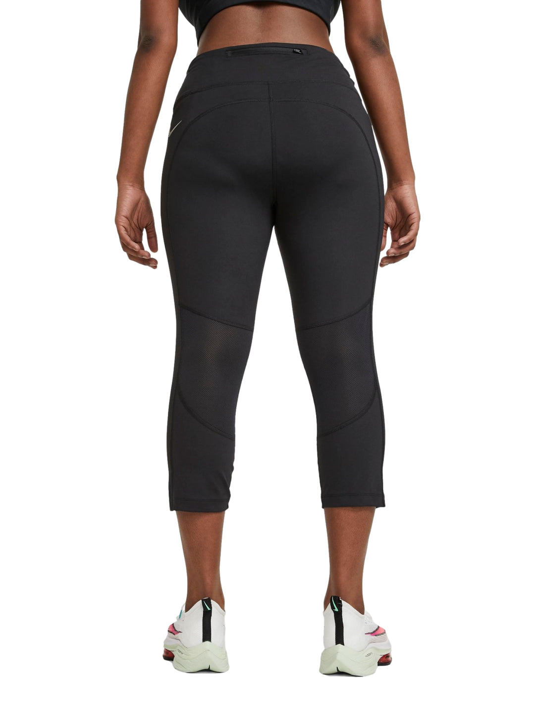 Mujer vistiendo mallas deportivas Nike color negro de corte crop y cintura alta.