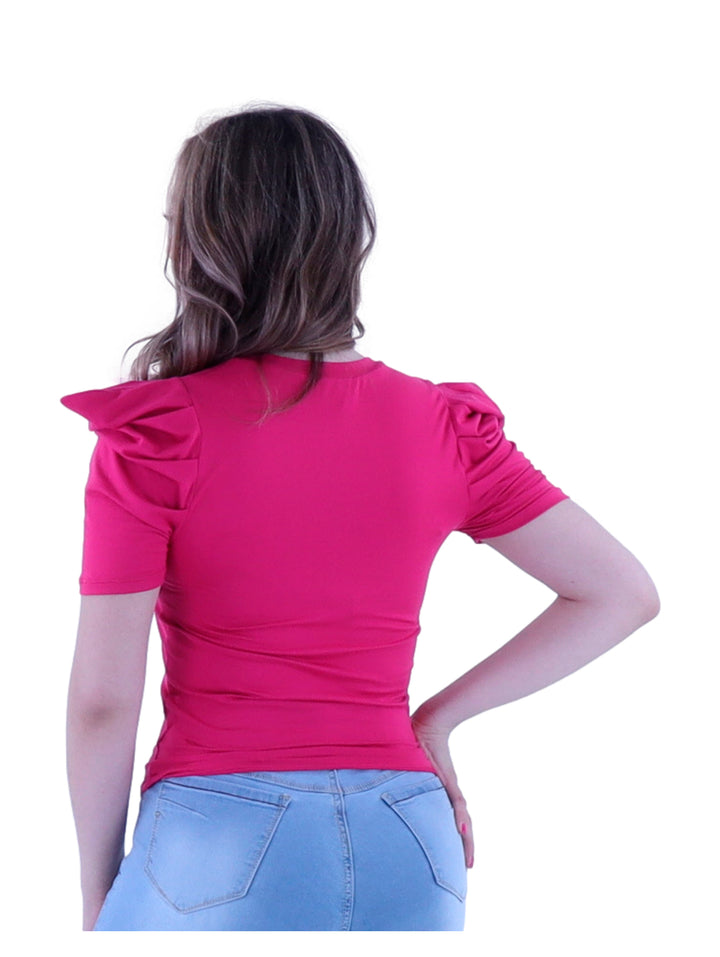 Mujer vistiendo blusa color fucsia de manga corta con detalles fruncidos en los hombros.