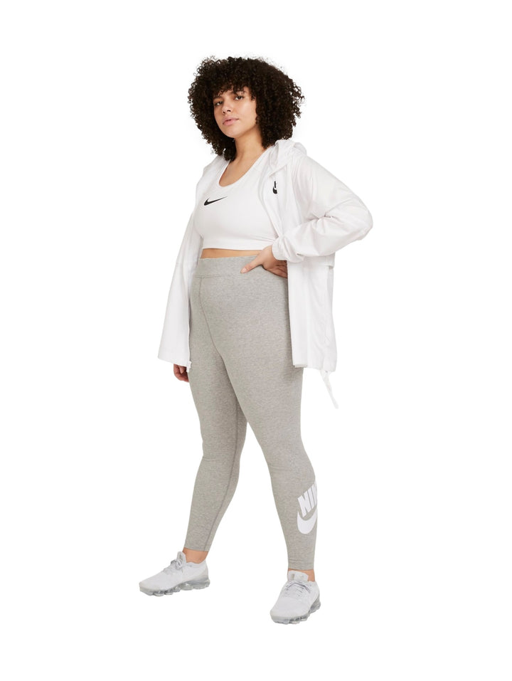 Mujer vistiendo mallas deportivas Nike de color gris jaspeado con logotipo blanco en la pierna.