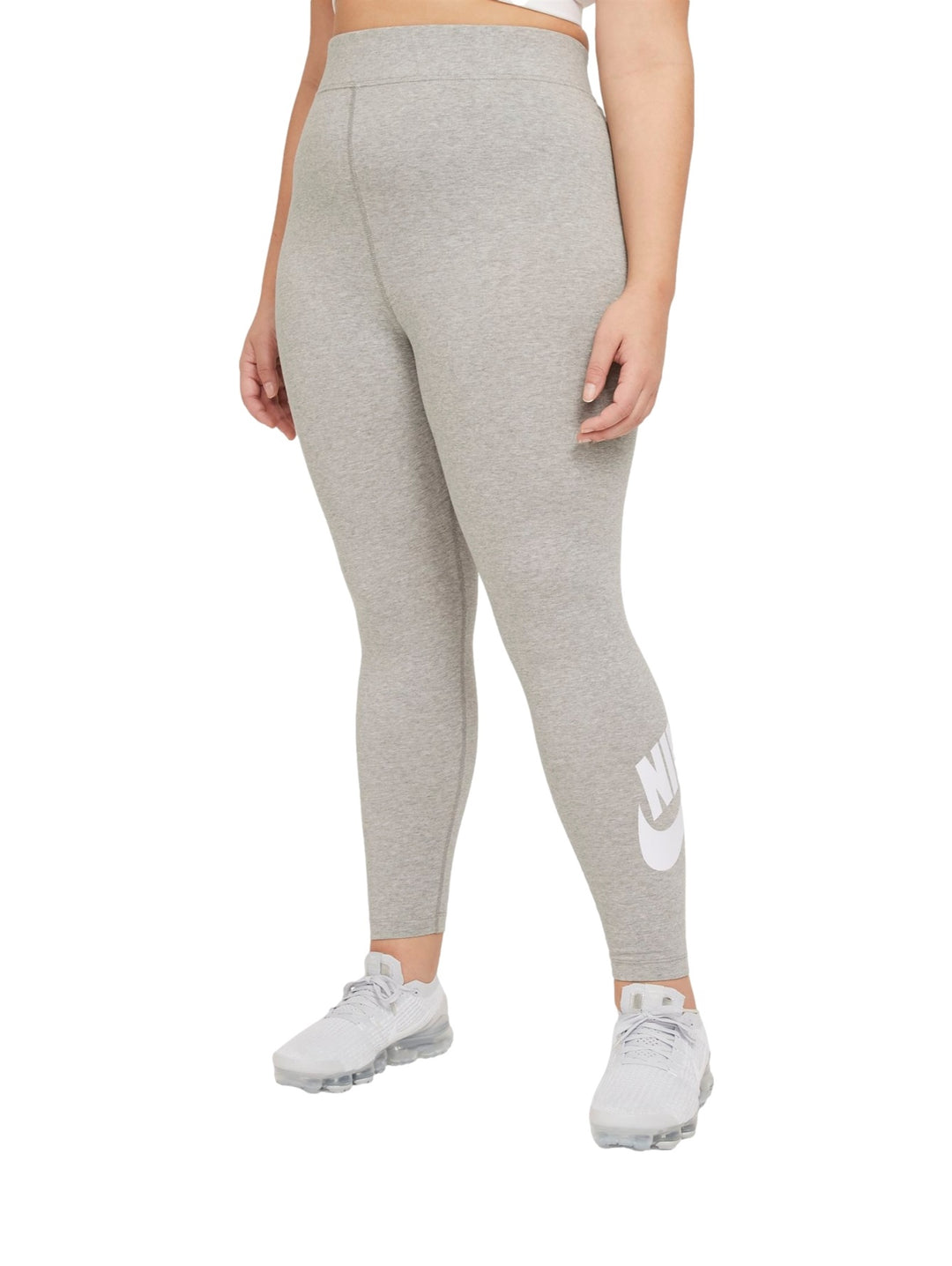 Mujer vistiendo mallas deportivas Nike de color gris jaspeado con logotipo blanco en la pierna.