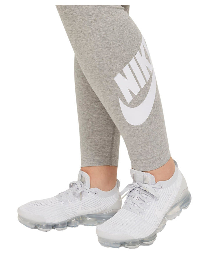 Mujer vistiendo mallas deportivas Nike de color gris jaspeado con logotipo blanco en la pierna.