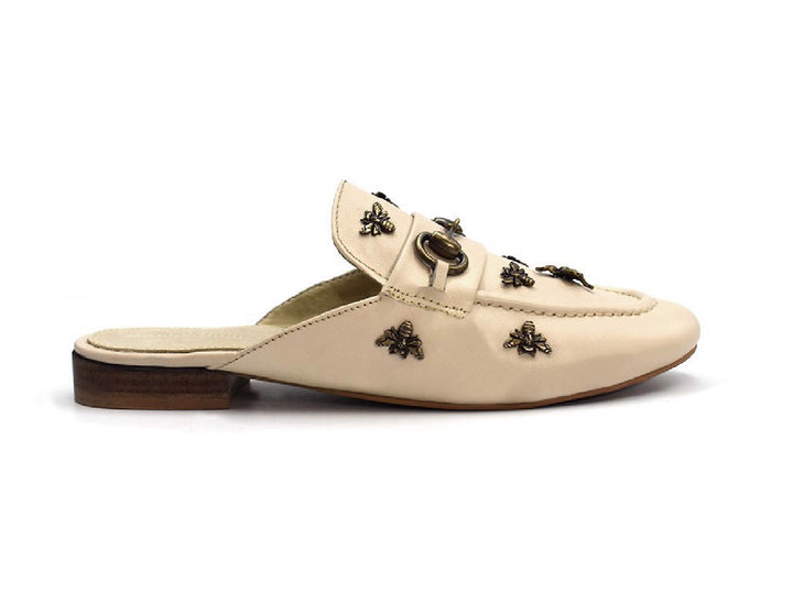 Zuecos color nude para mujer con detalles metálicos decorativos y tacón bajo marrón.