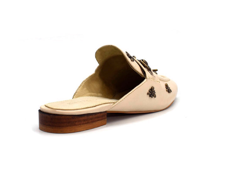 Zuecos color nude para mujer con detalles metálicos decorativos y tacón bajo marrón.
