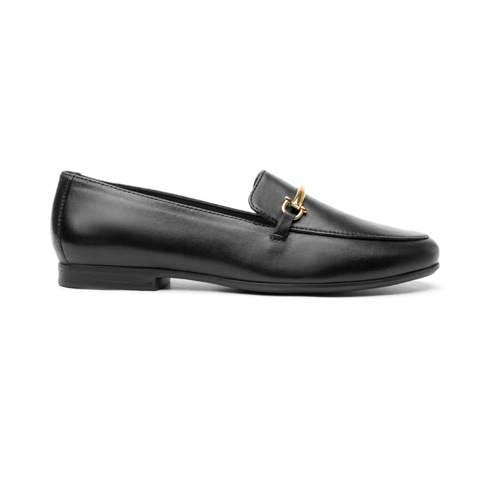 Zapato mocasín Flexi para mujer en color negro de cuero con un herraje metálico dorado en la parte superior.
