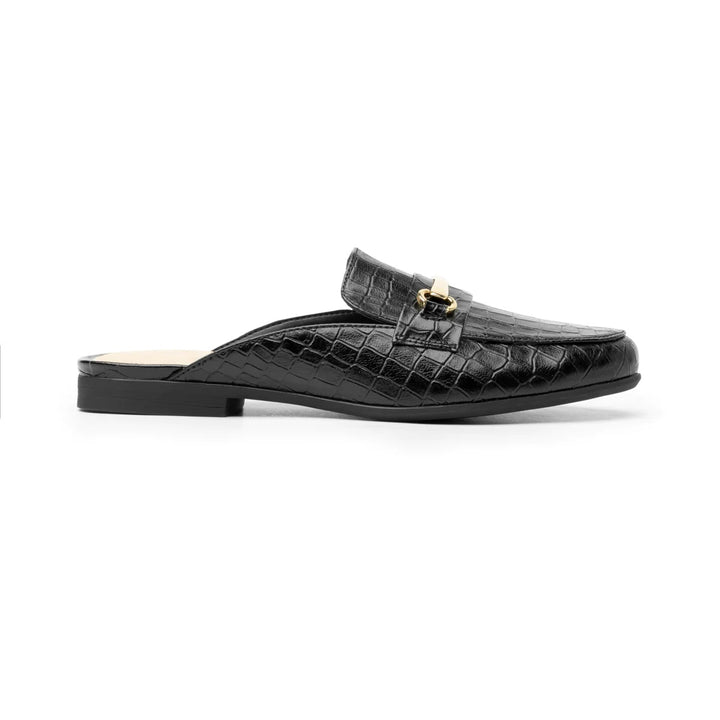 Zapato tipo mocasín destalonado color negro con textura de cocodrilo y hebilla dorada decorativa.
