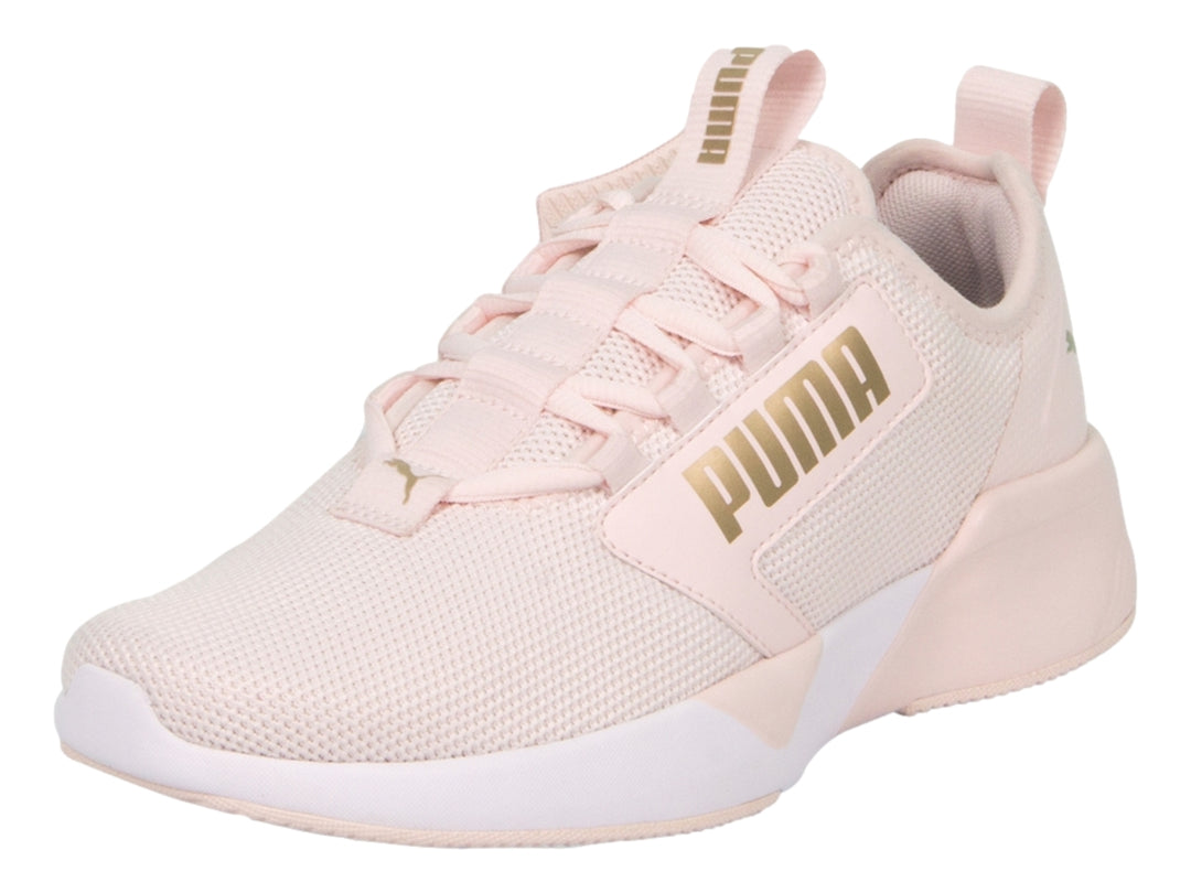 Zapatilla deportiva PUMA en color rosa claro con suela blanca y detalles de malla transpirable.