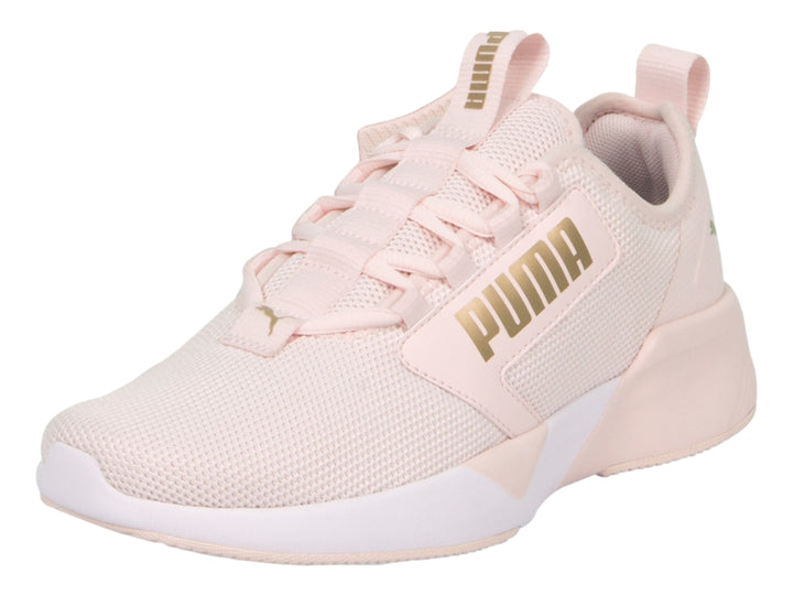 Zapatilla deportiva PUMA en color rosa claro con suela blanca y detalles de malla transpirable.