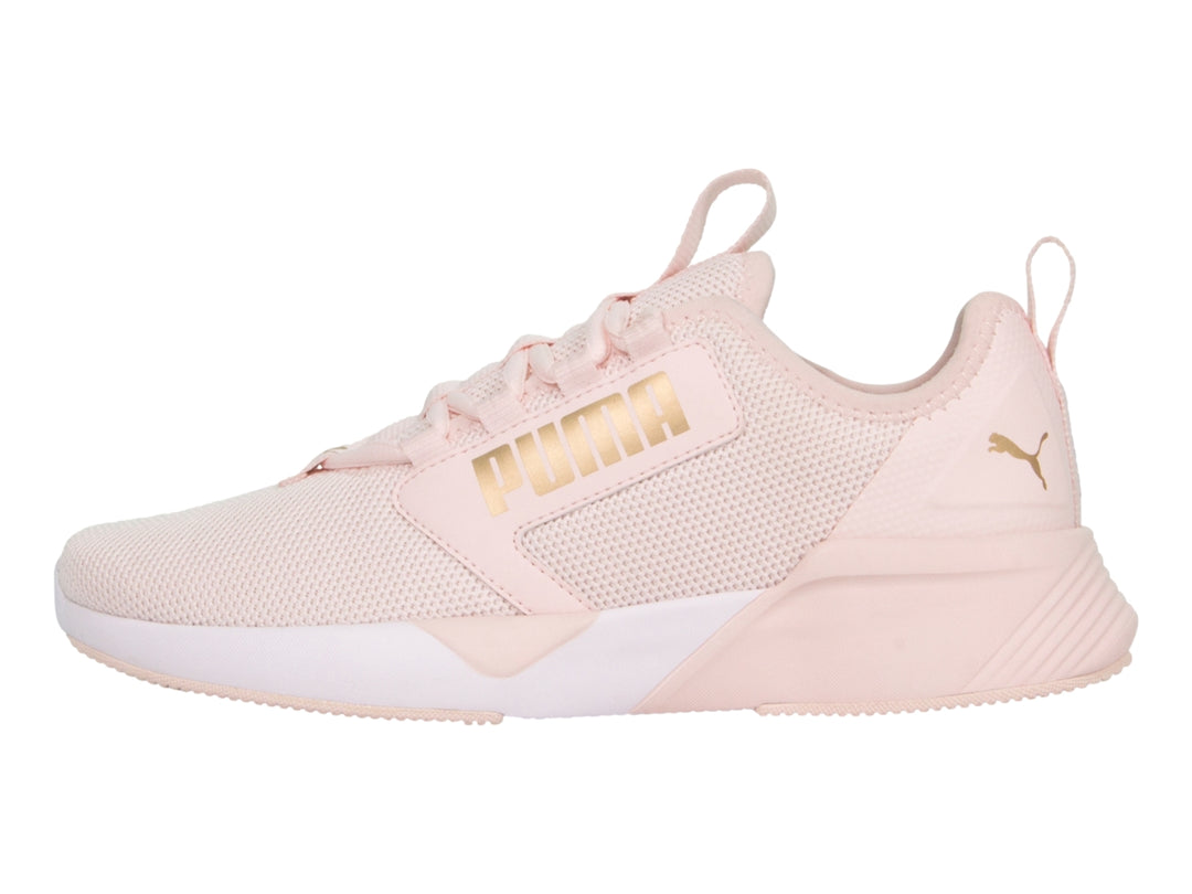 Zapatilla deportiva PUMA en color rosa claro con suela blanca y detalles de malla transpirable.