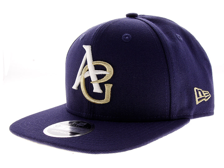 Gorra de béisbol New Era color azul marino con letras A y G bordadas en blanco y dorado.