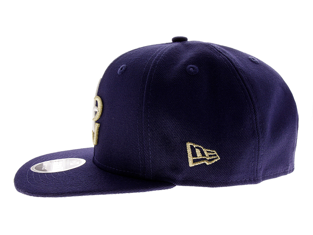 Gorra de béisbol New Era color azul marino con letras A y G bordadas en blanco y dorado.