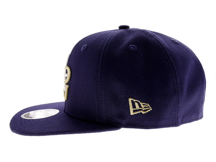 Gorra de béisbol New Era color azul marino con letras A y G bordadas en blanco y dorado.