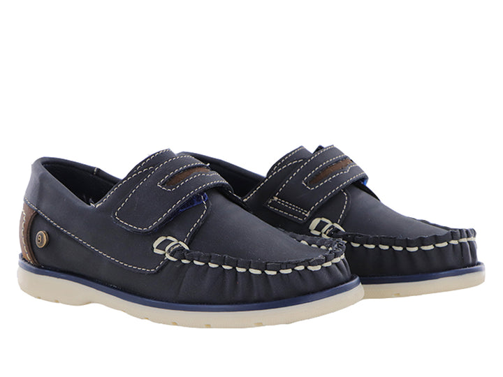 Zapatos tipo mocasín color azul marino para niño con suela blanca y detalles en café.