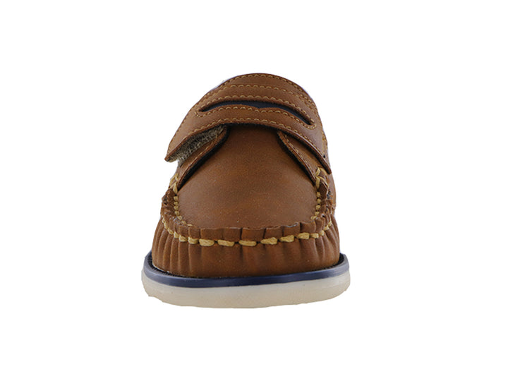 Zapatos tipo mocasín color tan para niño con correa ajustable y suela blanca con detalle azul.